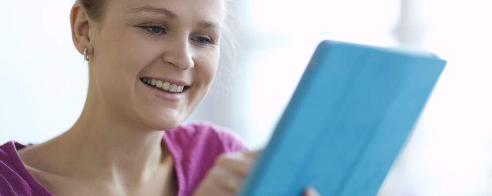 Young woman smiling as she surfs the internet