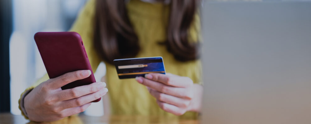 Woman hands with a credit card and cell phone